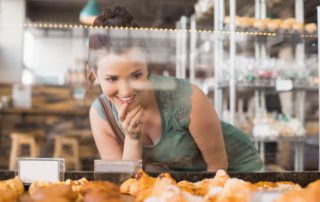 A woman looking at the display case in a bakery in Naples, FL.