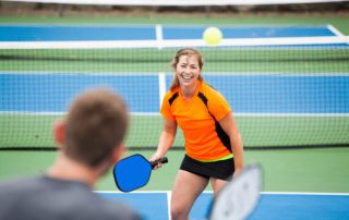 Two people playing pickleball during one of the annual Naples events.