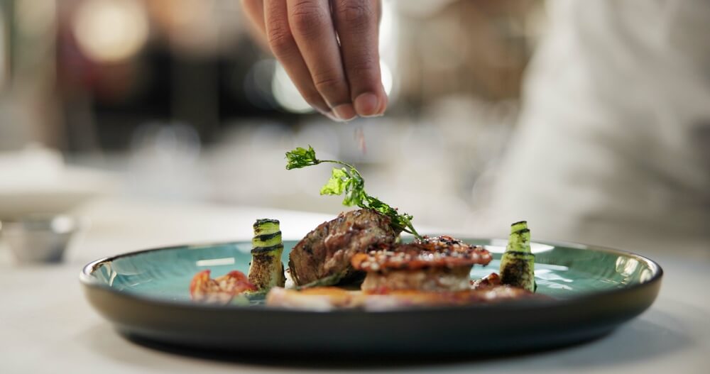A chef plating a dish at one of the best restaurants in Naples, Florida.