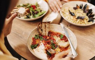 A person eating at one of the best places to eat in Naples.