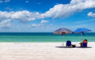 People relaxing on the beach, one of the best things to do on a late summer vacation to Naples, Florida.